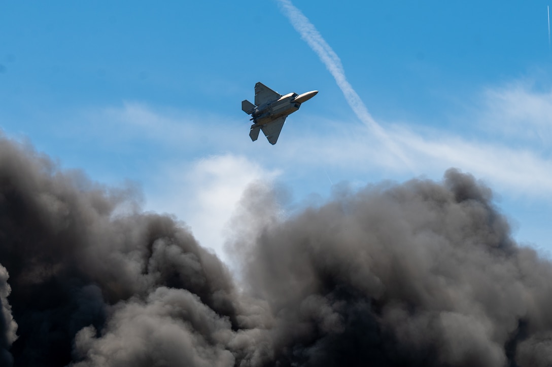 A plane passes over a large cloud of smoke.