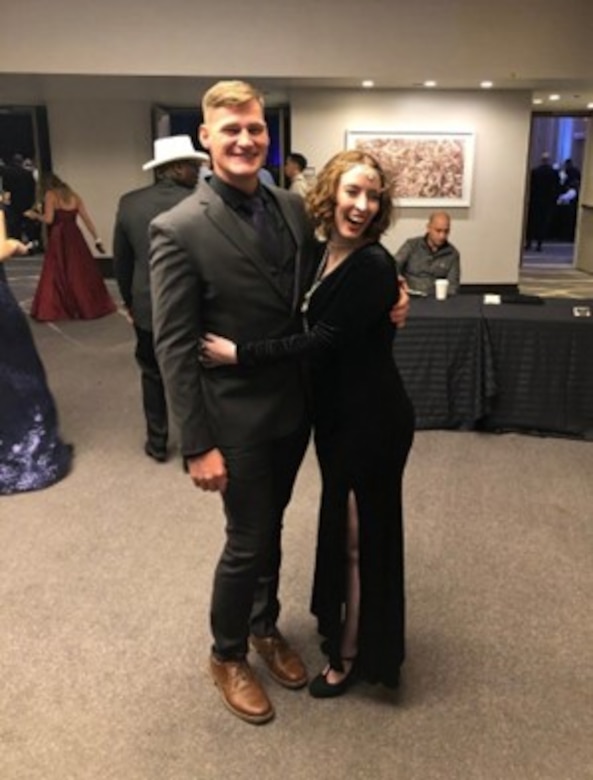 Male Solider in civilian suit pose with a woman in ball dress.