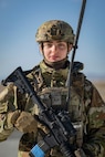 A portrait of of an Airman in battle gear looking into the camera