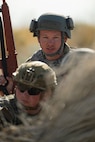 A photo of an Airman in battle gear holding a simulated M-4 rifle