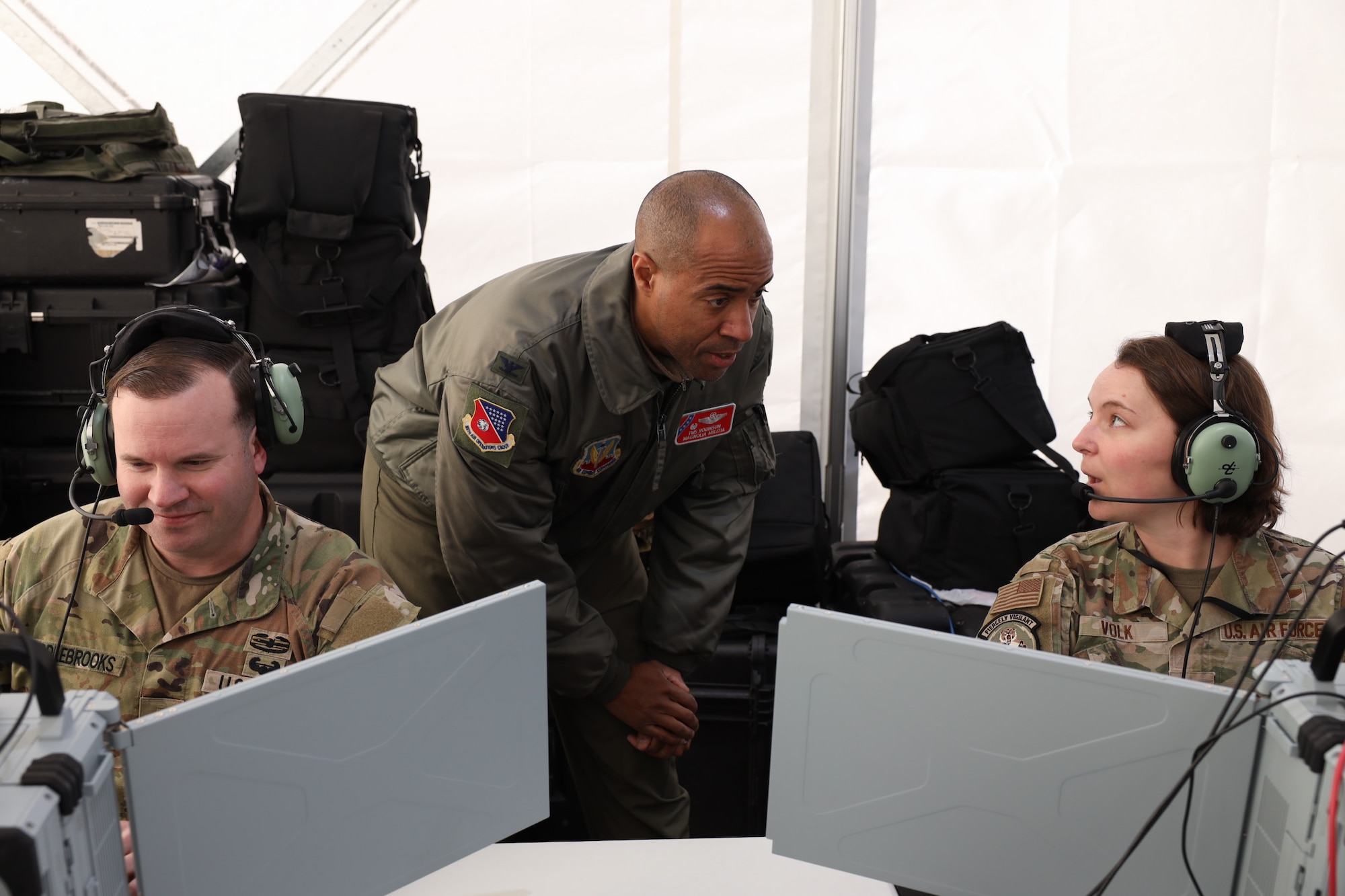 Col. Freddie Robinson, the Joint Air Component Coordination Element team director for the 186th Air Operations Group, facilitates communication with the Combined Joint Task Force and 1st Lt. Kaitlin Volk, an air battle manager, during Project Convergence Capstone 5 at the National Training Center, Fort Irwin, California, March 13, 2025. For the experiment, the JACCE was imbedded with the Army’s XVIII Airborne Corps to assist with doctrinal, technical and communication challenges between the CJTF and the TOC-L system. The JACCE team was the authoritative liaison of the Joint Force Air Component Commander and represented the JFACC at the CJTF. (Official Air Force Photo by Morgan Brown)