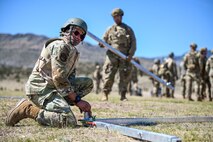 An Airman putting two metal pieces together.
