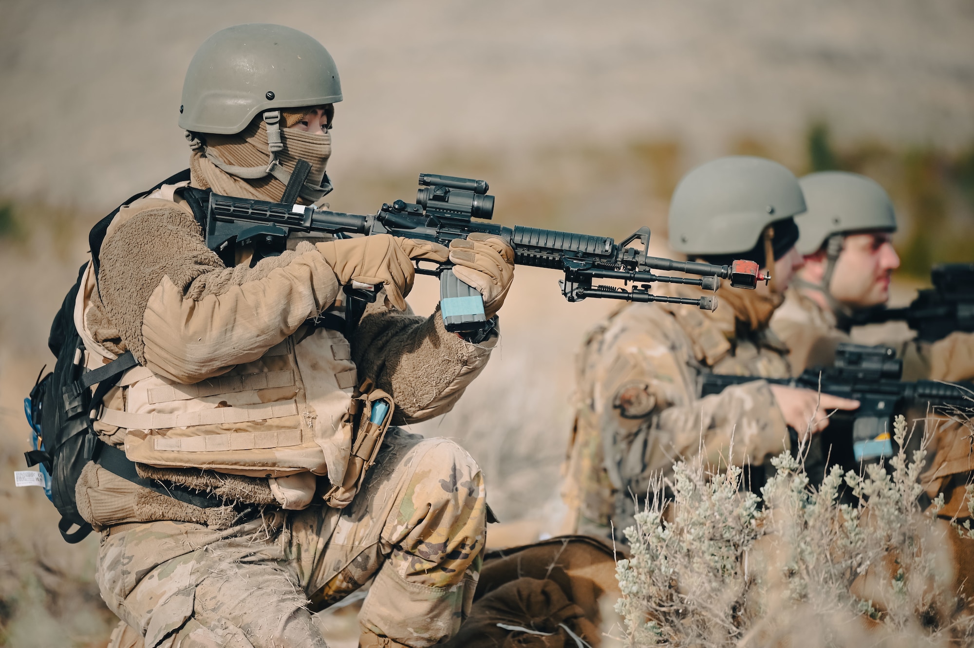 Airmen pointing their guns while kneeled