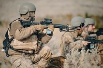 Airmen pointing their guns while kneeled