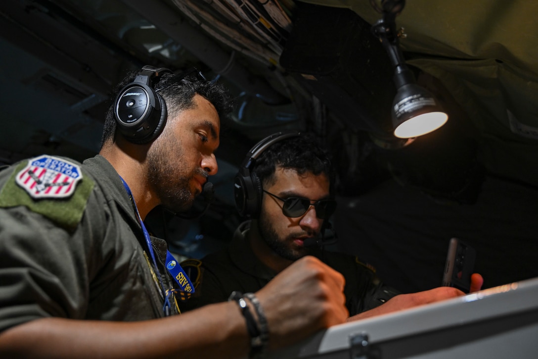 U.S. Air Force Staff Sgt. Elisaul Penafiel Alvarez, left, and Senior Airman Ata Chaudhry, both boom operators assigned to the 756th Air Refueling Squadron, review refueling plans aboard a KC-135 Stratotanker, April 22, 2025. The 459th ARW supports both training and operational missions worldwide, enhancing U.S. Air Force mobility and readiness. (U.S. Air Force photo by Senior Airman Gianluca Ciccopiedi)