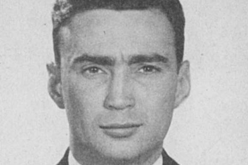 A man in a suit poses for a photo.