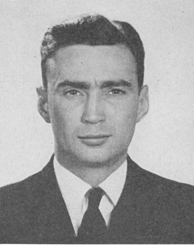 A man in a suit poses for a photo.