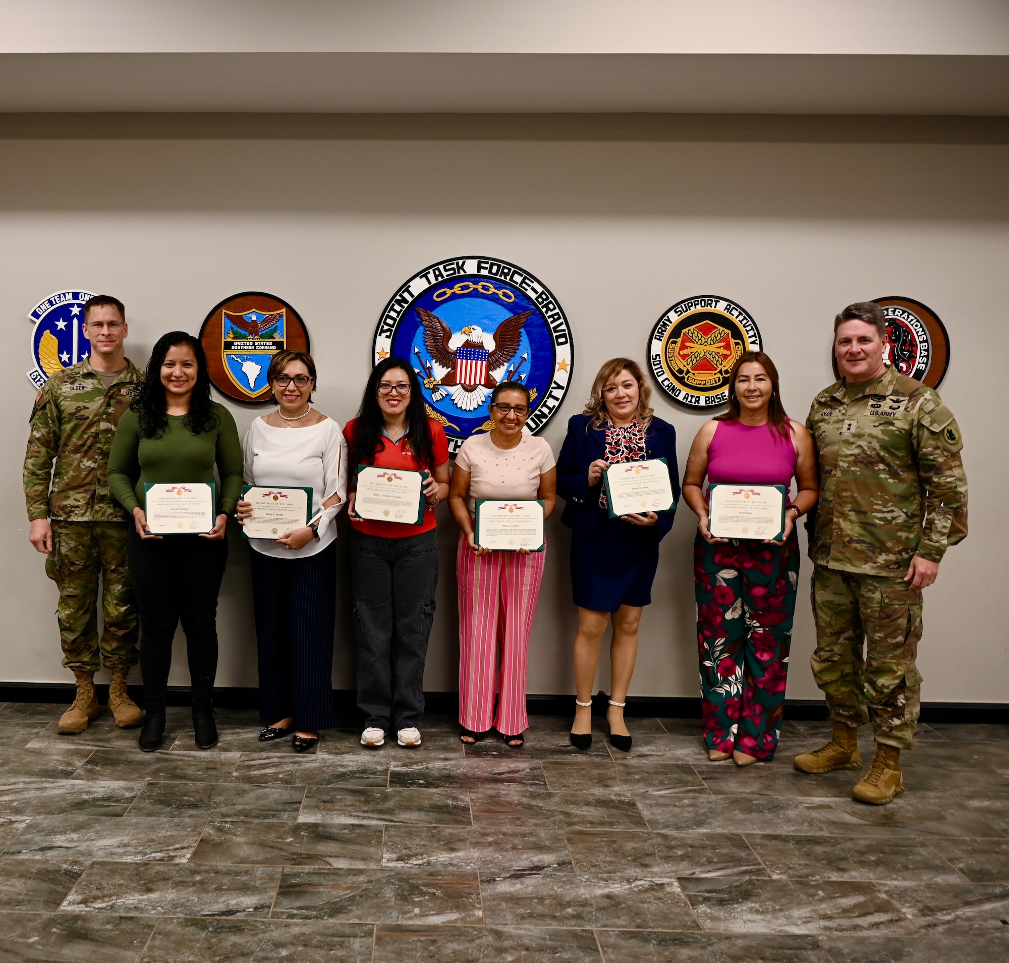 Maj. Gen. Phillip Ryan, Commanding General, U.S. Army Southern Command and Command Sgt. Maj. Eric Olson, U.S. Southern Command pose for a photo with FSNs who were awarded Meritorious Civilian Service Medals.