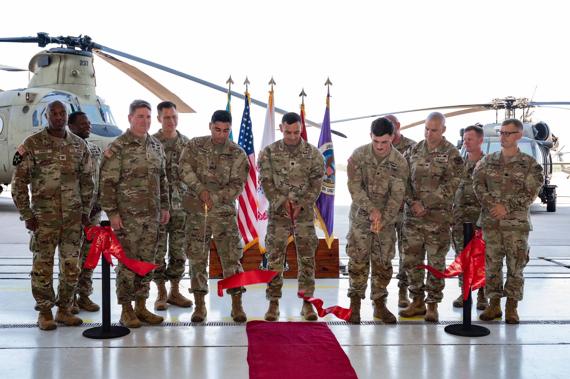Members from Joint Task Force Bravo, 1-228th Aviation Regiment, Army Support Activity and Army Southern Command leadership join junior aircraft maintainers in cutting the ribbon dedicating a new hangar at Soto Cano Air Base.