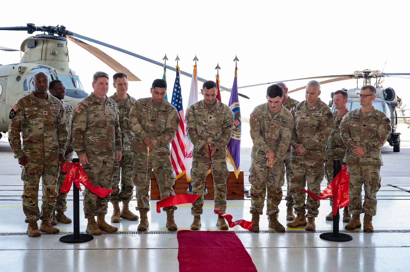 Members from Joint Task Force Bravo, 1-228th Aviation Regiment, Army Support Activity and Army Southern Command leadership join junior aircraft maintainers in cutting the ribbon dedicating a new hangar at Soto Cano Air Base.