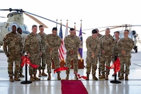 Members from Joint Task Force Bravo, 1-228th Aviation Regiment, Army Support Activity and Army Southern Command leadership join junior aircraft maintainers in cutting the ribbon dedicating a new hangar at Soto Cano Air Base.