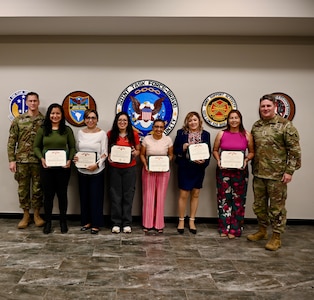Maj. Gen. Phillip Ryan, Commanding General, U.S. Army Southern Command and Command Sgt. Maj. Eric Olson, U.S. Southern Command pose for a photo with FSNs who were awarded Meritorious Civilian Service Medals.