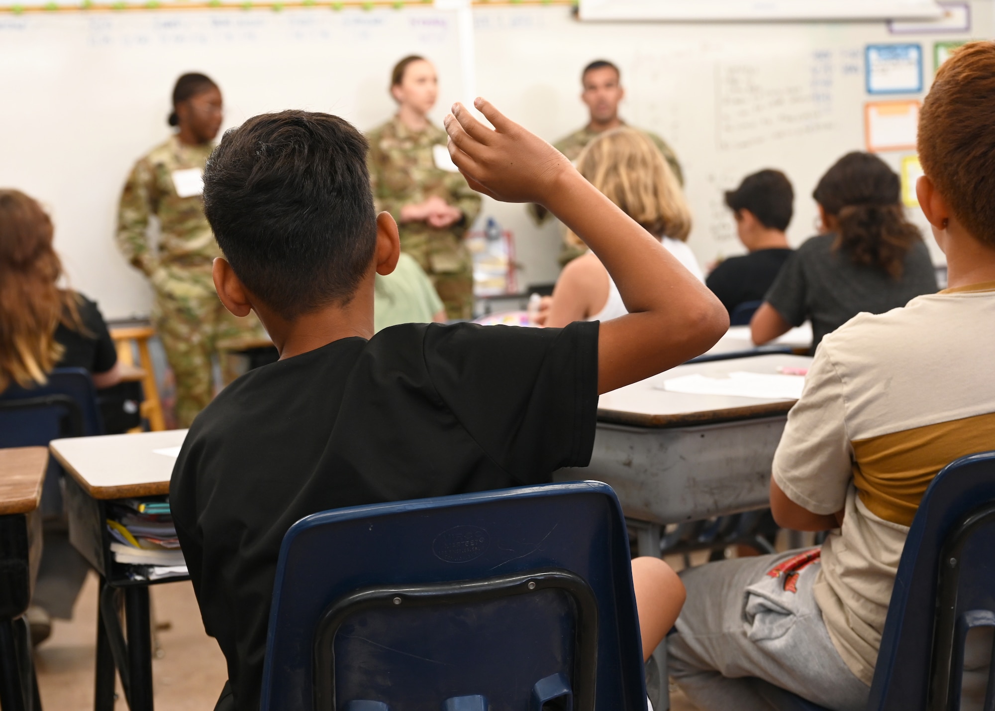 A student at Lineweaver Elementary School asks U.S. Airmen assigned to Davis-Monthan Air Force Base a question, in Tucson, Arizona, April 28, 2025. The Airmen spoke to the children about their jobs and life in the military to build and foster relationships with the community. (U.S. Air Force photo by Staff Sgt. Abbey Rieves)