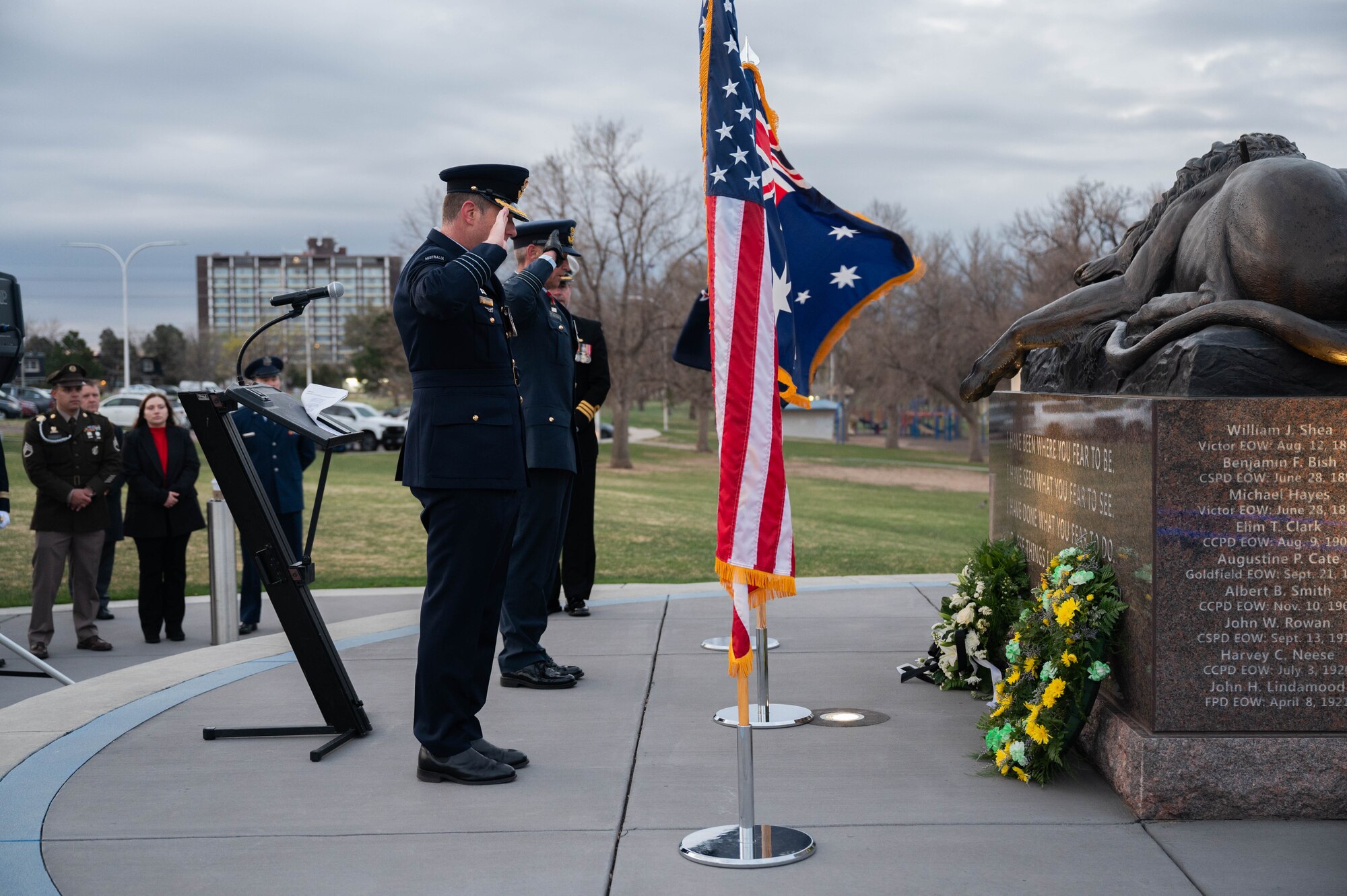 Col. Edgar Gonzalez and Lt. Col. Mark Waters salute the flower wreaths they have placed at a memorial site.