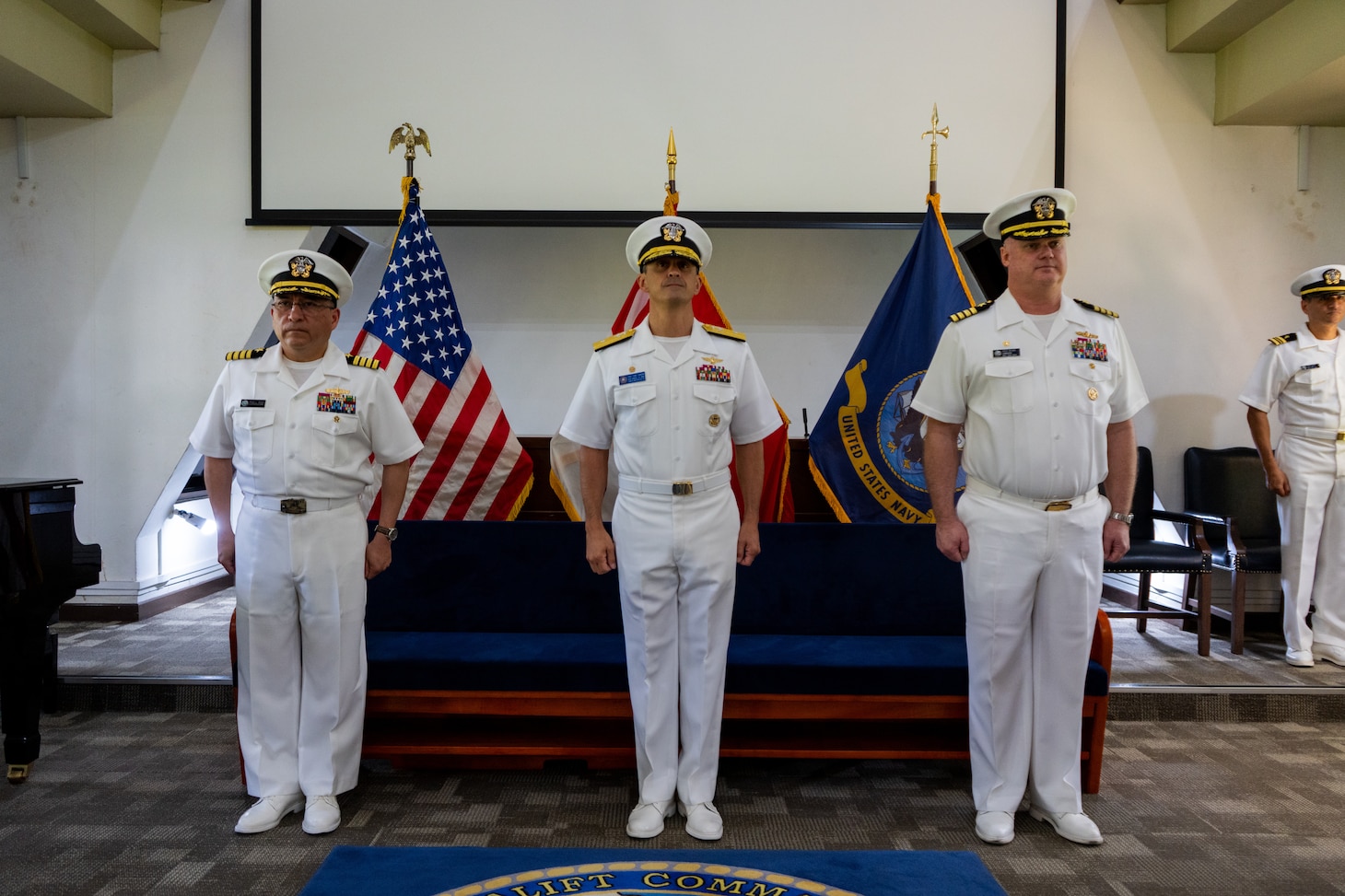 Left to right, Capt. David L. Reyes, incoming commander, Military Sealift Command Far East;  Rear Adm. Todd F. Cimicata, Commander, Logistics Group Western Pacific/ Task Force 73; and Capt. Robert R. Williams, outgoing commander, Military Sealift Command Far East, stand at attention during a change of command ceremony at the Singapore Naval Installation in Sembawang, April 30, 2025.