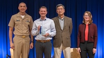 Jason Patrick Kelly (center left) stands with Naval Surface Warfare Center, Carderock Division leadership at an annual Command Awards Ceremony after being recognized as the Platform Integrity Department 2024 Emerging Scientist/Engineer award recipient in West Bethesda, Md. on April 29, 2025. From left: Carderock Commanding Officer, Capt. Chris Matassa, Jason Patrick Kelly, Carderock Acting Technical Director, Dr. Paul Shang and Platform Integrity Deputy Department Head, Nancy Adler.