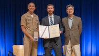 Naval Surface Warfare Center Carderock Division’s Commanding Officer, Capt. Chris Matassa (left), and Acting Technical Director, Dr. Paul Shang (right), present Joe Walther with a Department of the Navy Meritorious Civilian Service Award at an annual Command Awards Ceremony in West Bethesda, Md. on April 29, 2025.