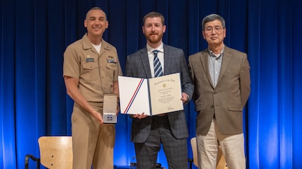 Naval Surface Warfare Center Carderock Division’s Commanding Officer, Capt. Chris Matassa (left), and Acting Technical Director, Dr. Paul Shang (right), present Joe Walther with a Department of the Navy Meritorious Civilian Service Award at an annual Command Awards Ceremony in West Bethesda, Md. on April 29, 2025.