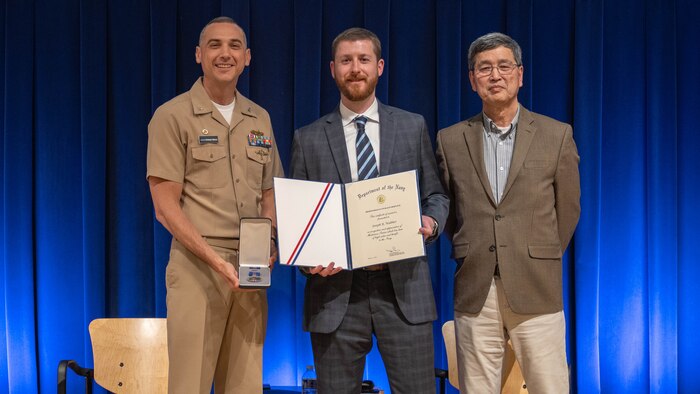 Naval Surface Warfare Center Carderock Division’s Commanding Officer, Capt. Chris Matassa (left), and Acting Technical Director, Dr. Paul Shang (right), present Joe Walther with a Department of the Navy Meritorious Civilian Service Award at an annual Command Awards Ceremony in West Bethesda, Md. on April 29, 2025.