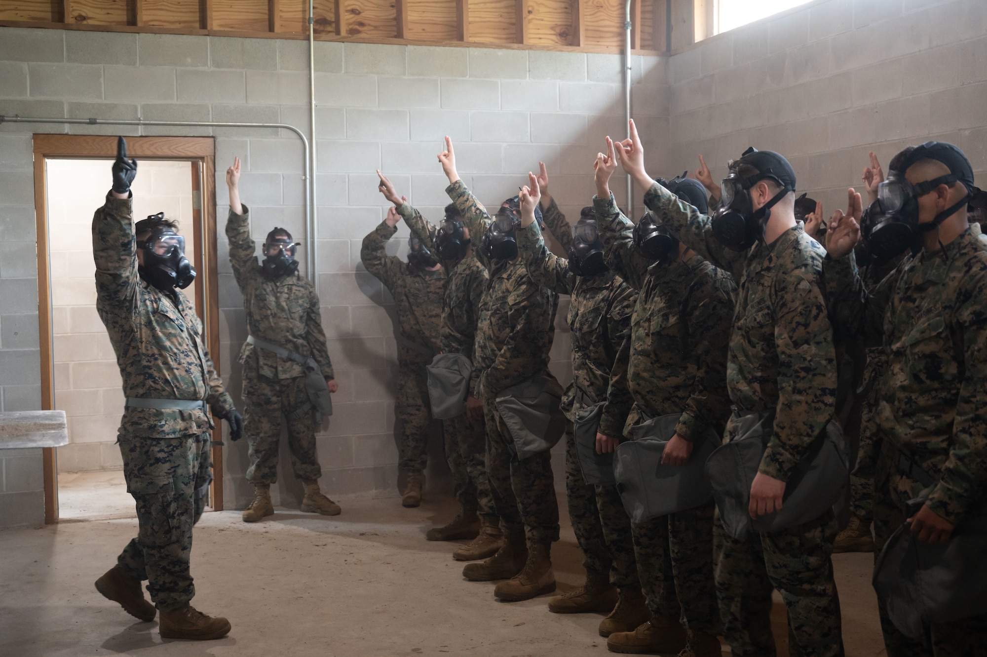 U.S. Marines assigned to Marine Aircraft Group 49, prepare to break the seal of their gas masks at Joint Base McGuire-Dix-Lakehurst, N.J., April 26, 2025. Chemical, Biological, Radiological, and Nuclear (CBRN) training is intended to educate, prepare and build confidence of service members in the event of unprecedented chemical warfare attacks. (U.S. Air Force photo by Airman 1st Class Luisa E. Dugan)