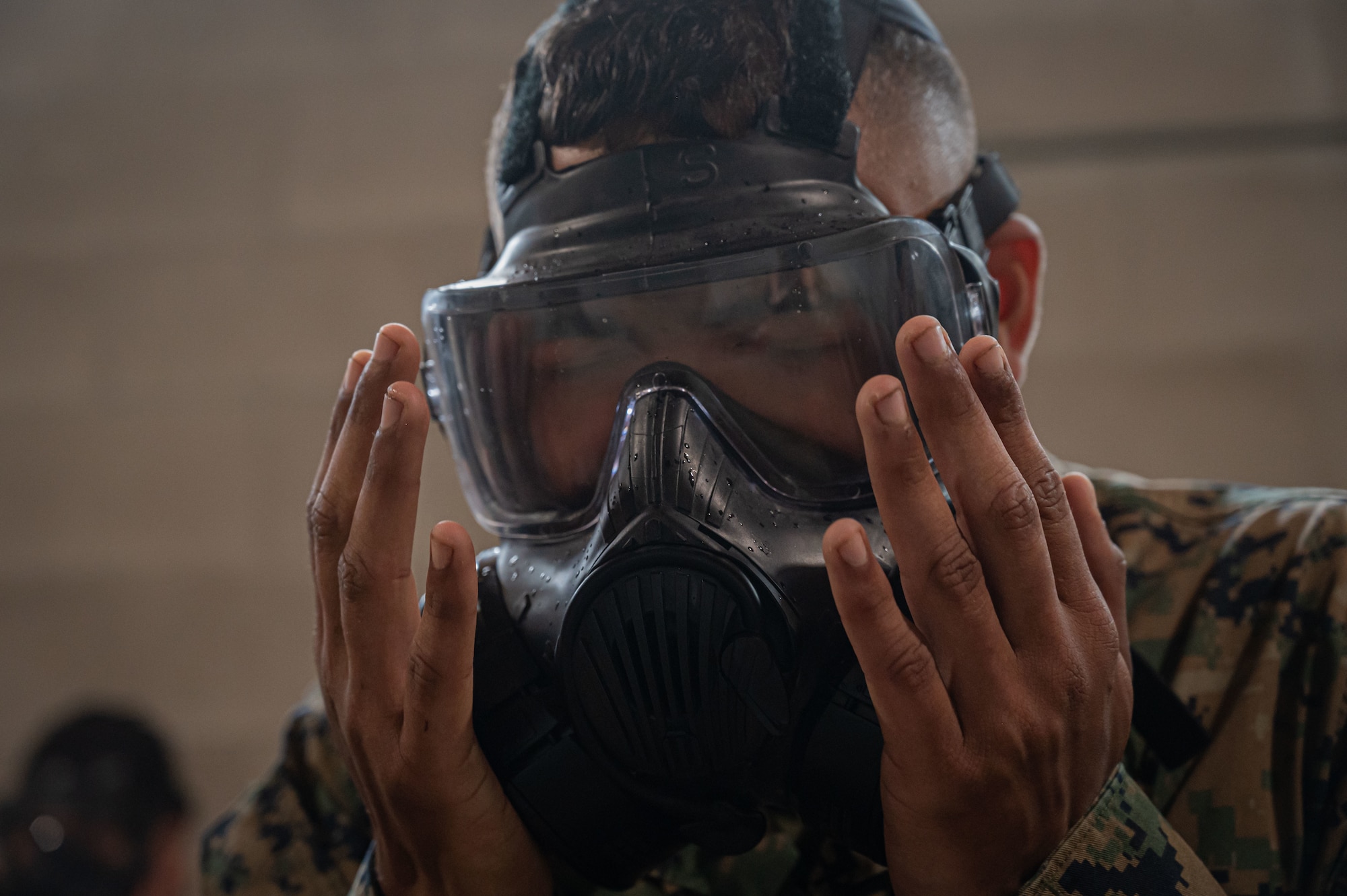 A U.S. Marine Corps Marine assigned Marine Aircraft Group 49, reseals his gas mask during chemical, biological, radiological, and nuclear (CBRN) training at Joint Base McGuire-Dix-Lakehurst, N.J., April 26, 2025. CBRN training is intended to educate, prepare and build confidence of service members in the event of unprecedented chemical warfare attacks.(U.S. Air Force photo by Airman 1st Class Luisa E. Dugan)
