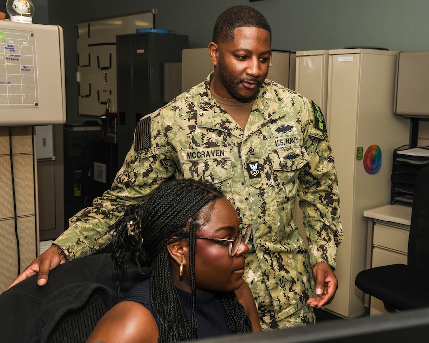 Hospital Corpsman 1st Class Davonte McCraven, assigned to Navy Medicine Readiness and Training Command (NMRTC) Bethesda, trains Hospital Corpsman 3rd Class Jocylen Tynes on submitting evaluations.