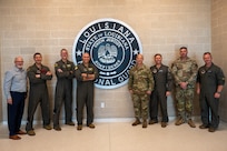 Leadership from the 2nd Bomb Wing, 159th Fighter Wing, Louisiana National Guard and Chennault International Airport pose for a group photo in the National Guard facilities at Chennault International Airport in Lake Charles, La., April 29, 2025. The event brought together senior leaders to assess the utility of Chennault’s infrastructure for future missions and build a framework for more regular collaboration between the 2nd Bomb Wing, 159th Fighter Wing, and Louisiana National Guard. (U.S. Air Force photo by Senior Airman Seth Watson)