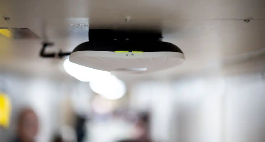 Photo of a Starshield wireless access point mounted on the ceiling of a ship.