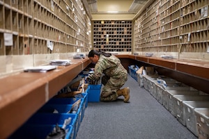 Service member looks through box.