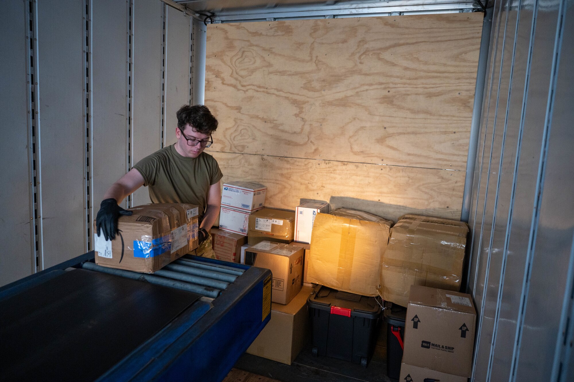 Service member loads parcel onto truck.
