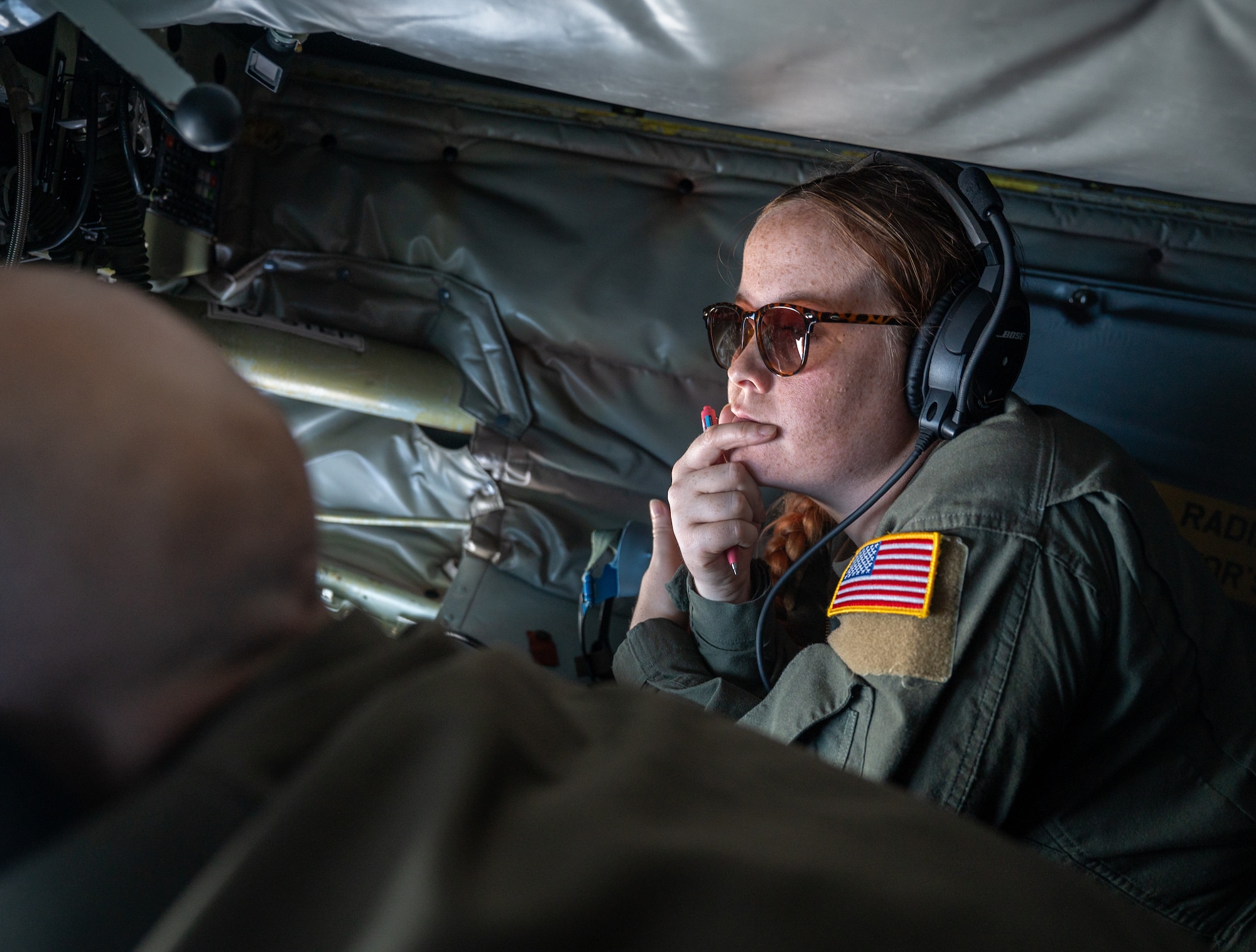 A U.S. Air Force Airman watches another Airman perform aerial refueling operations.