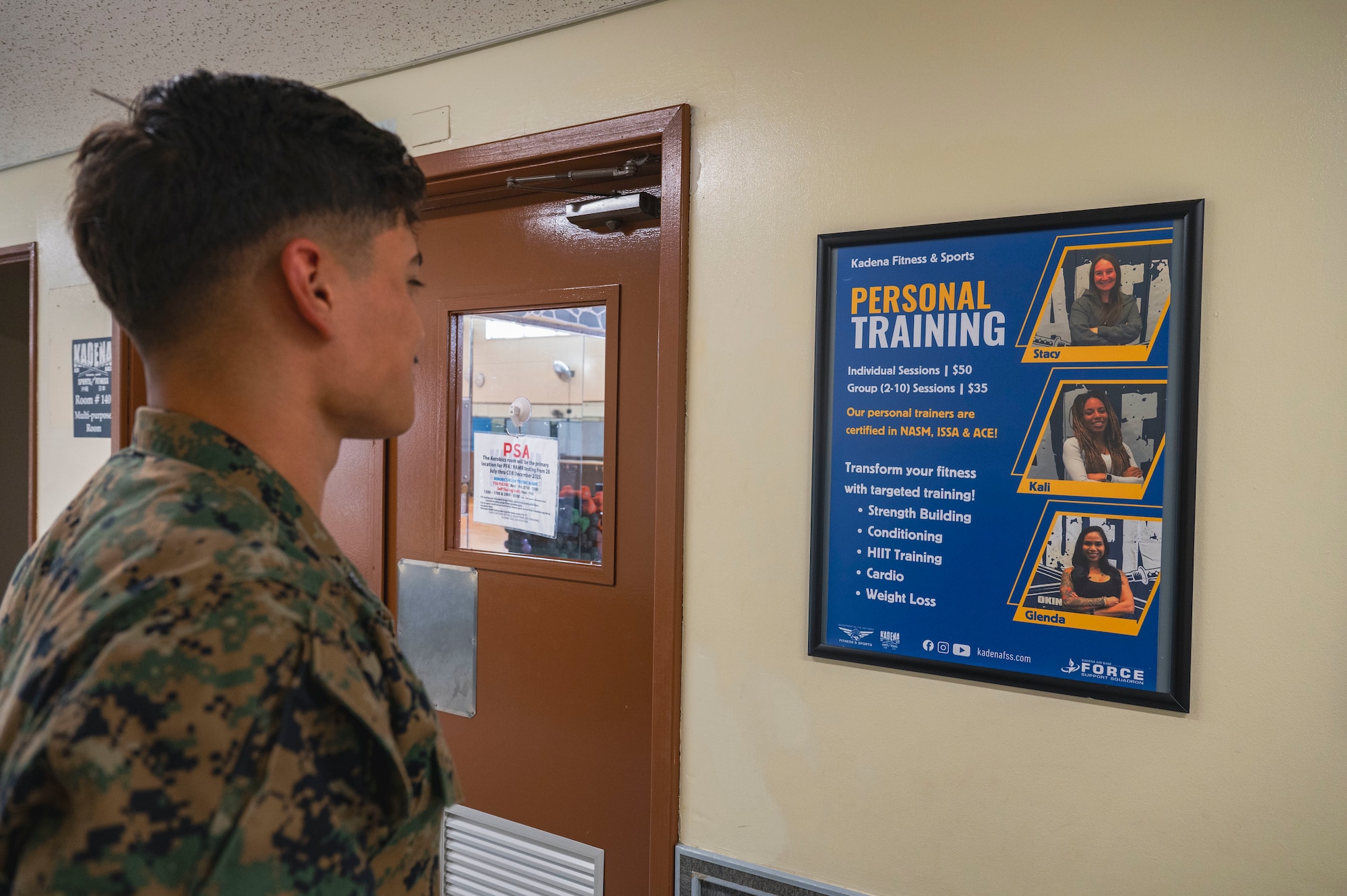 A U.S. Marine looks at a personal training poster at Risner Fitness Center on Kadena Air Base, Japan, July 30, 2025.