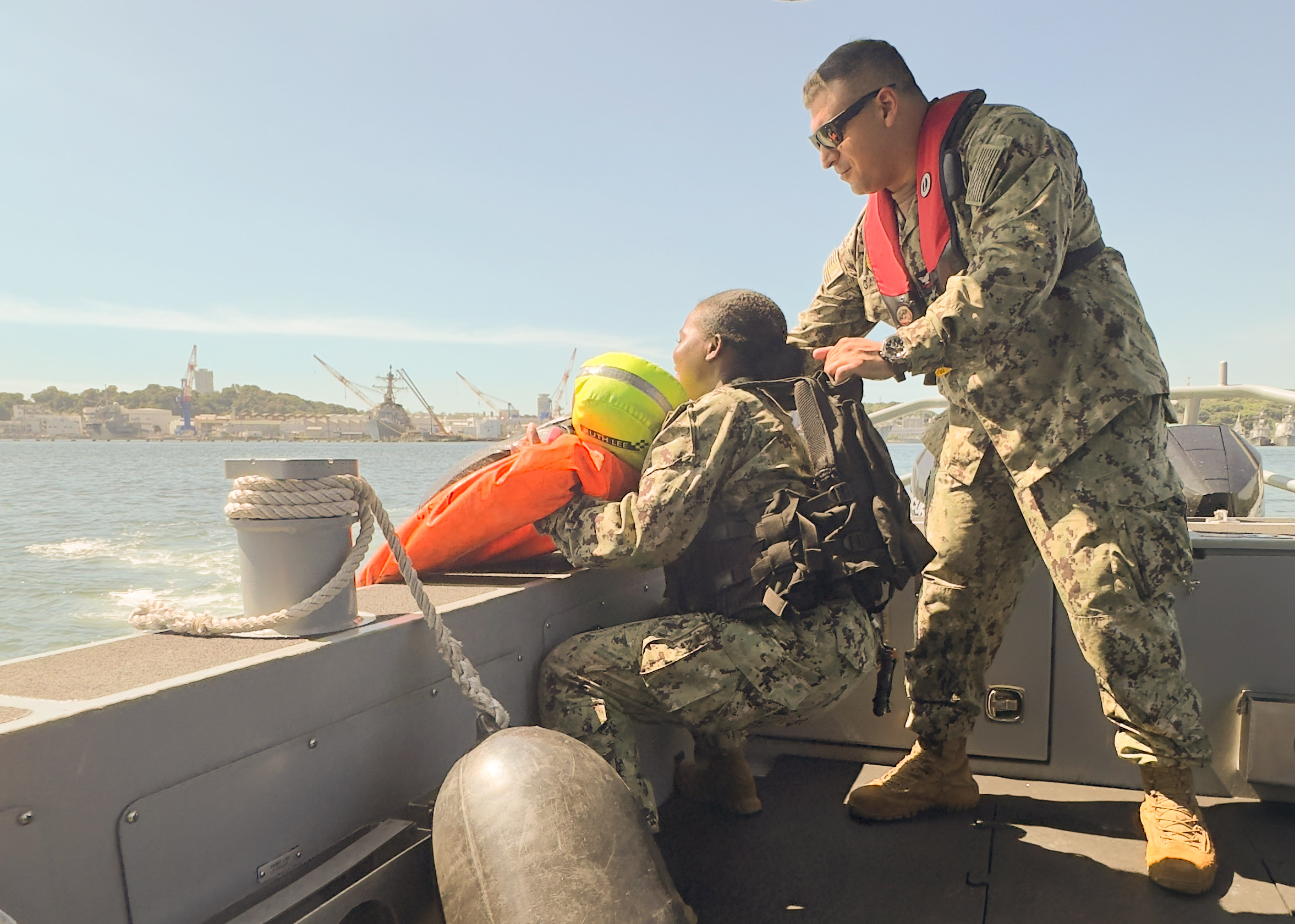Master-at-Arms 2nd Class Aaron M. Garcia (right) and Master-at-Arms Seaman Nehema Kilassa (left), both assigned to Commander, Fleet Activities Yokosuka (CFAY) harbor security department, conduct a man overboard training aboard a harbor security boat.