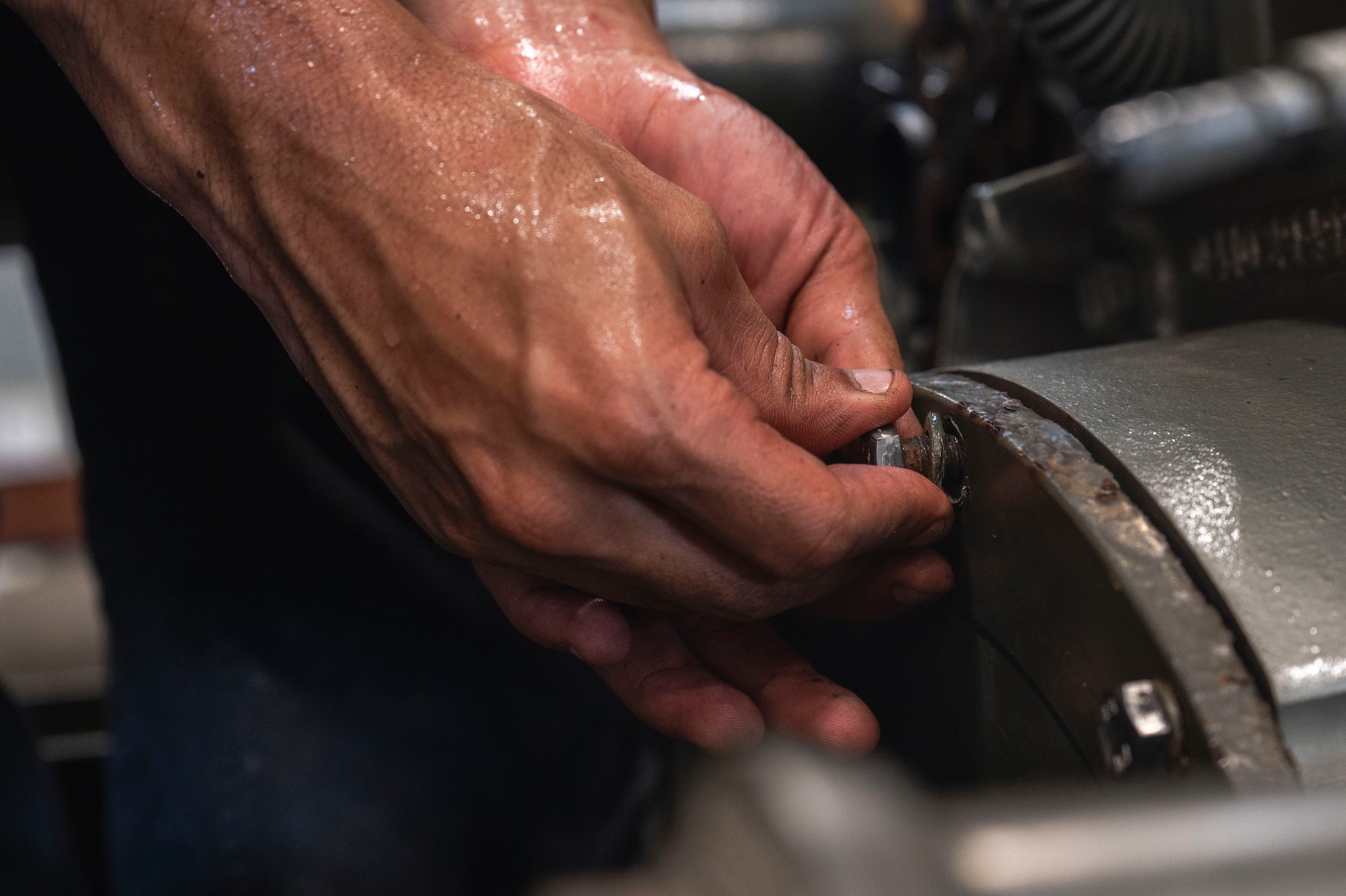U.S. Air Force Senior Airman Seth Aguon, 18th Logistics Readiness Squadron vehicle maintenance technician, places a screw inside an engine for a line trailer at Kadena Air Base, Japan, July 30, 2025.
