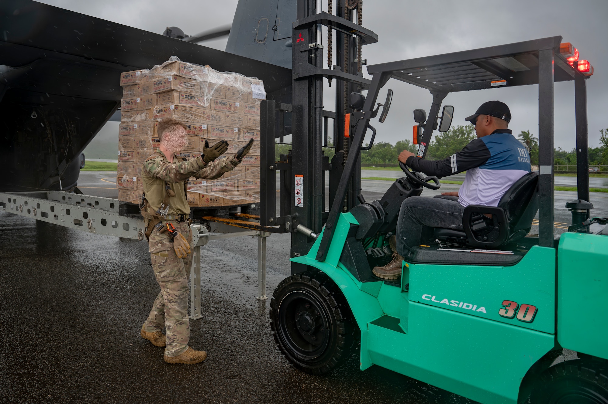 Philippine Marines secure Department of Social Welfare and Development family food packs delivered by CV-22 Ospreys.
