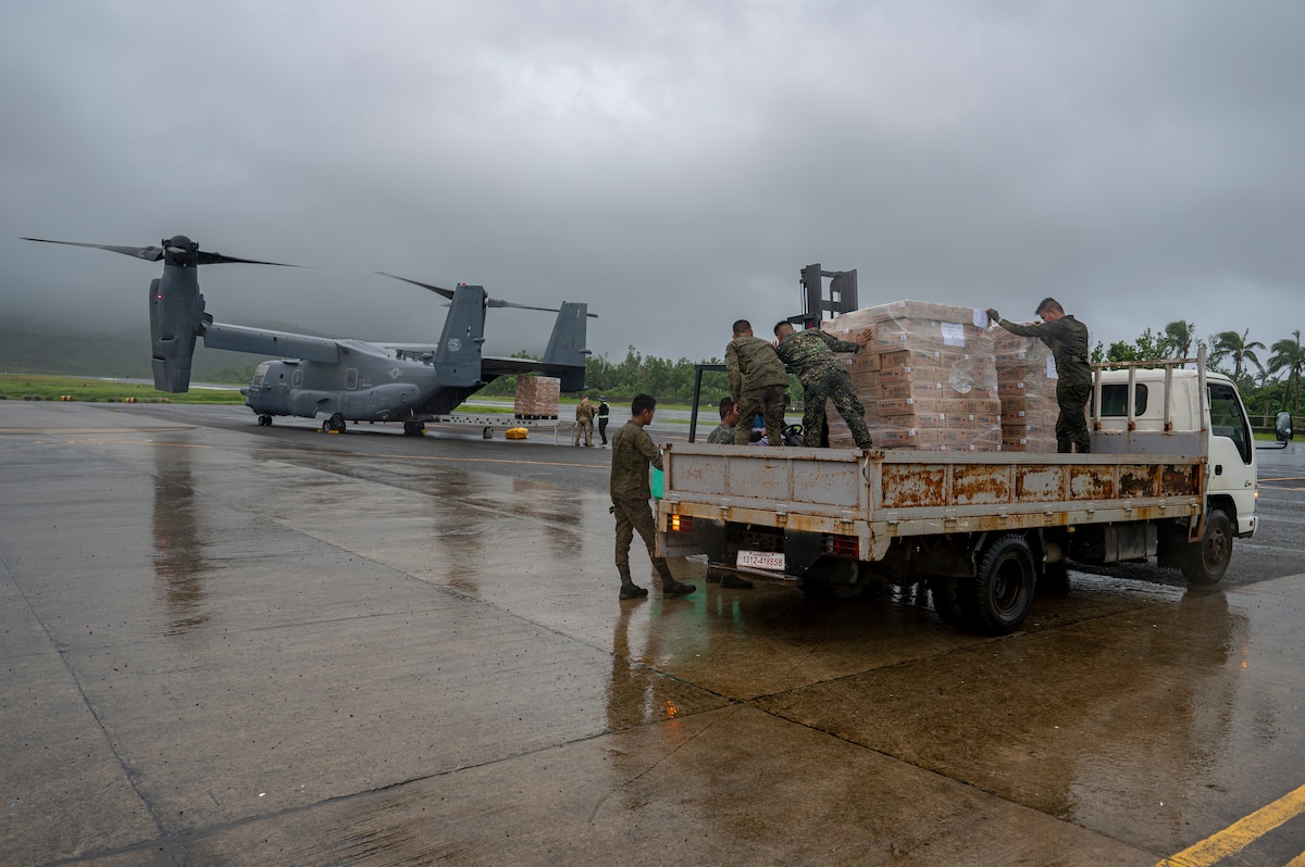 Philippine Marines secure Department of Social Welfare and Development family food packs delivered by CV-22 Ospreys.