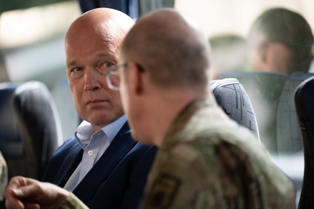 A close-up of the ambassador listening to the DCOM who is blurred in the foreground