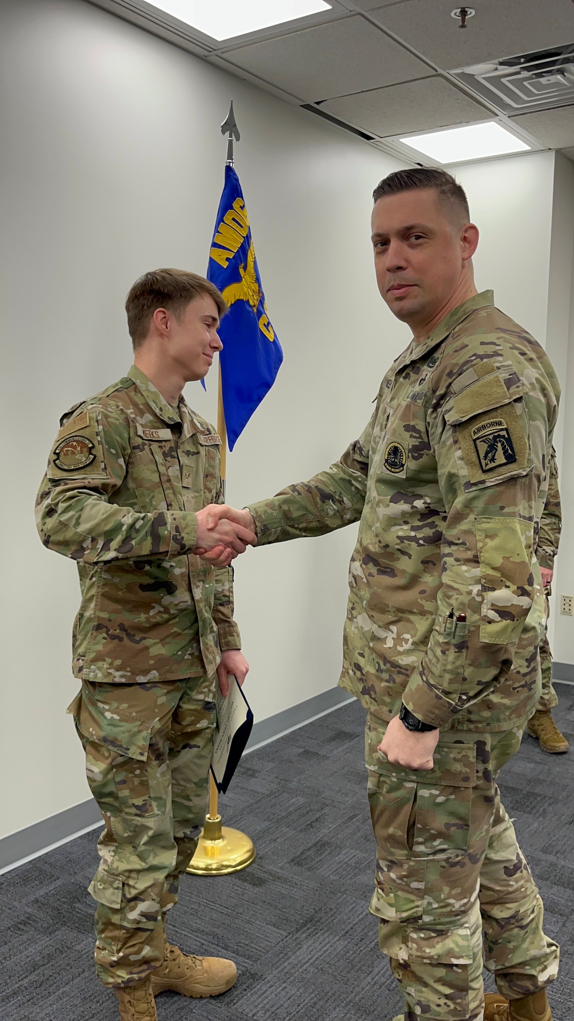 Two service members shake hands