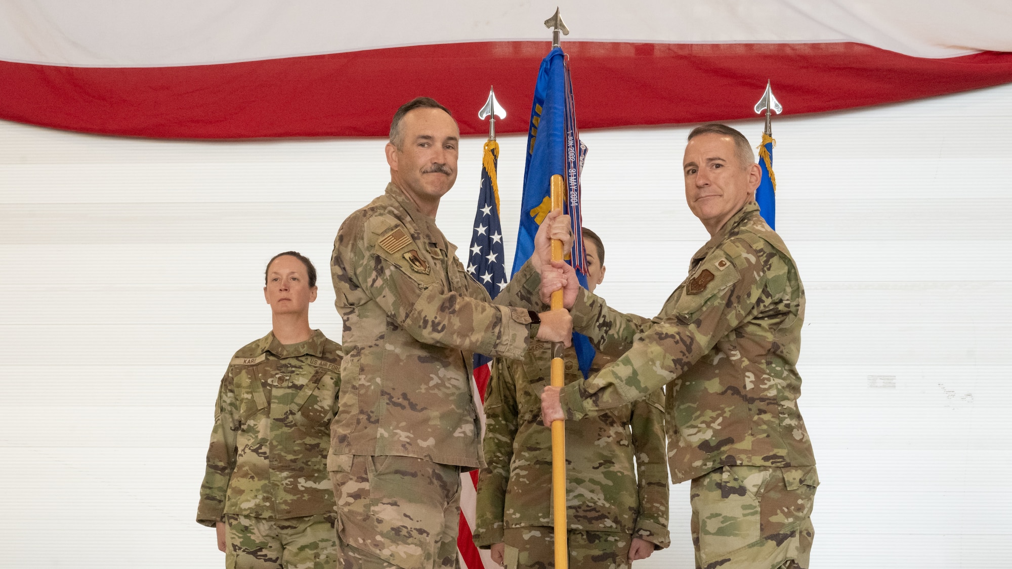 U.S. Air Force Col. Jesse Lamarand, 5th Bomb Wing commander, presents U.S. Air Force Col. Michael McCarthy, 5th Medical Group (5MDG) commander, the guidon during the 5MDG change of command ceremony at Minot Air Force Base, North Dakota, July 31, 2025. The passing of the guidon represents McCarthy’s assumption of command of the 5MDG.