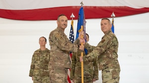 U.S. Air Force Col. Jesse Lamarand, 5th Bomb Wing commander, presents U.S. Air Force Col. Michael McCarthy, 5th Medical Group (5MDG) commander, the guidon during the 5MDG change of command ceremony at Minot Air Force Base, North Dakota, July 31, 2025. The passing of the guidon represents McCarthy’s assumption of command of the 5MDG.