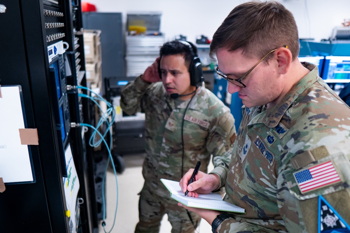 Airmen operating electronics equipment