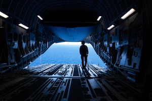 Senior Airman looks out over the water from a C-17 Globemaster III