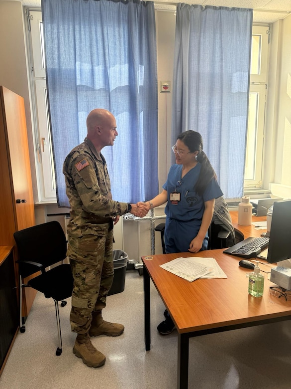U.S. Army Col. Christopher Howell, Kentucky Medical Detachment (MEDDET) commander, presents a commander coin to Landstuhl Regional Medical Center staff.