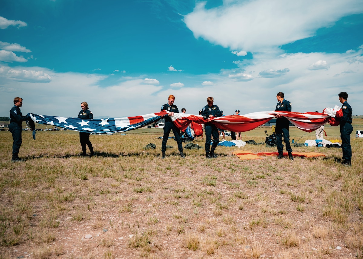 U.S. Air Force Academy Parachute Team “Wings of Blue” cadets begin to space out to unfurl the American flag to perform a 13-fold procedure during the Wings Over Wyoming Air Show at F.E. Warren Air Force Base, Wyo., July 26, 2025. As part of the air show, the cadets demonstrate elite parachuting skills while embodying the Air Force’s core values through discipline, precision and service to the public. (U.S. Air Force photo by Staff Sgt. Michael A. Richmond)
