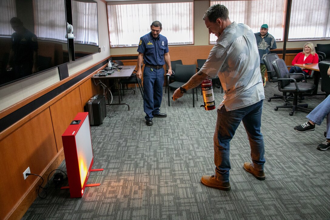 Josh Moskowitz, Honolulu District Safety and Occupational Health Specialist, uses a fire extinguisher simulator during a training session with fire inspectors from the Federal Fire Department April 4, 2025 on Fort Shafter, Hawaii.