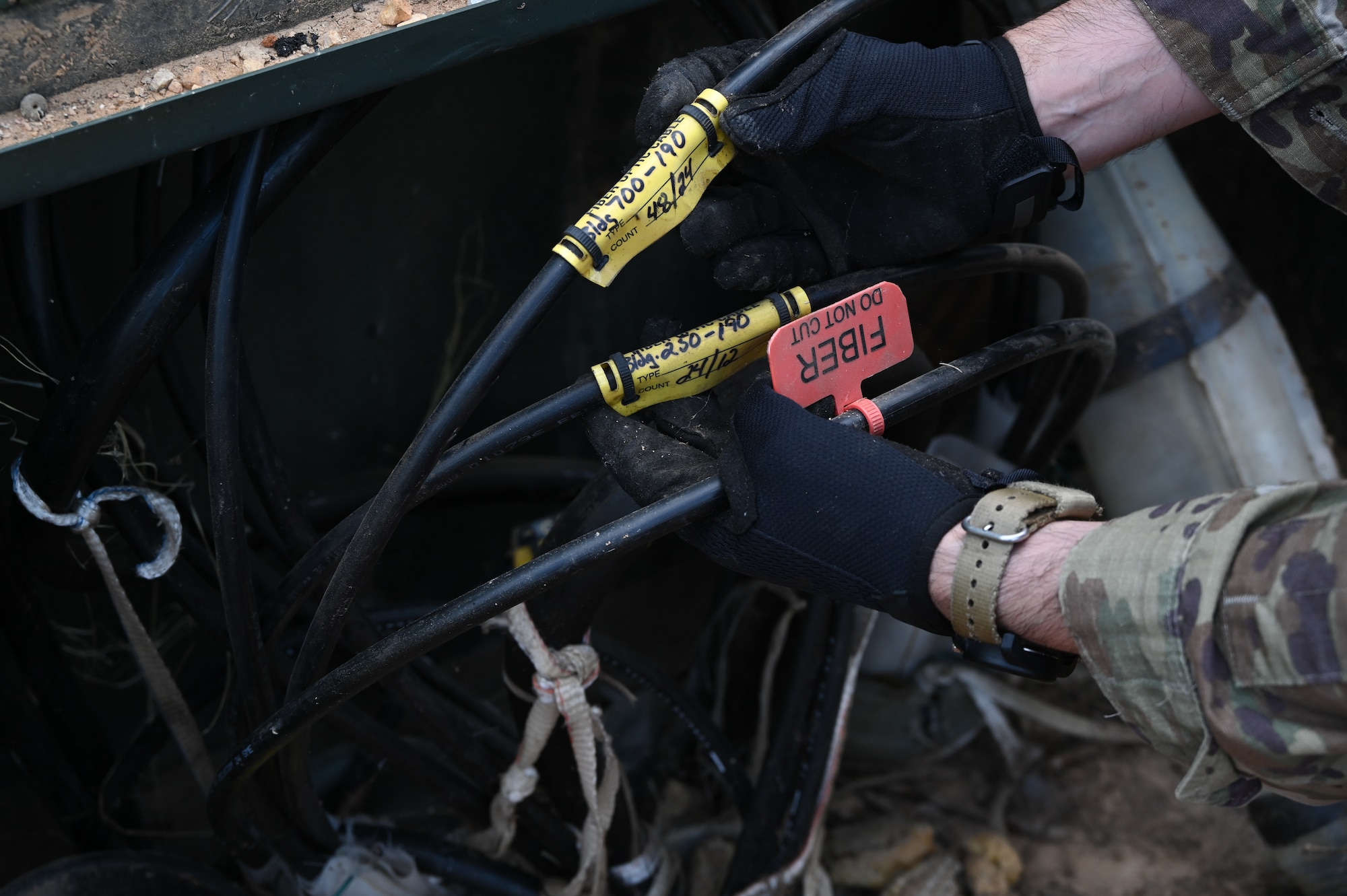 U.S. Air Force Tech. Sgt. Christopher Harden, an airmen with the 117th Communications Squadron, identifies cabling used for the base wi-fi.