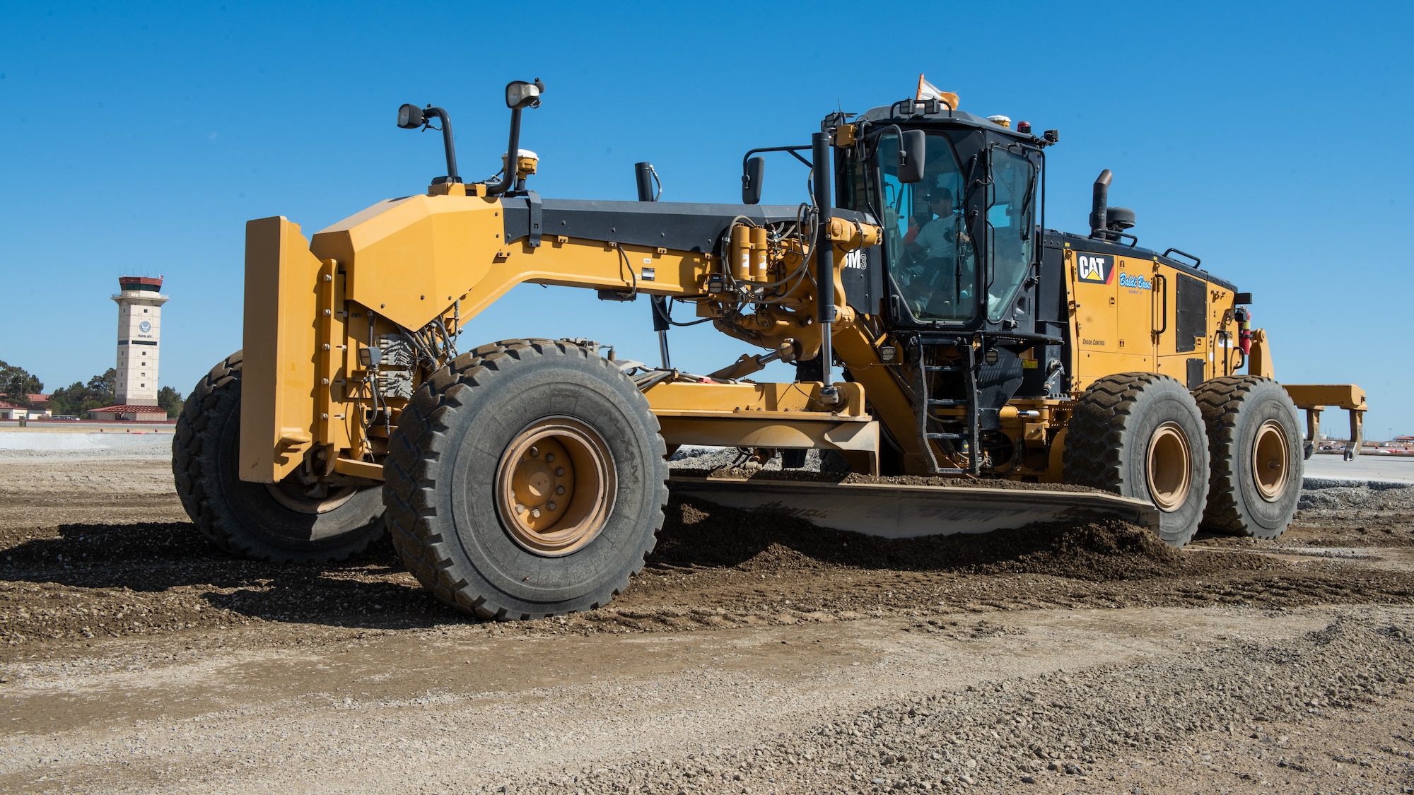 Construction crew working on flight line with a grader