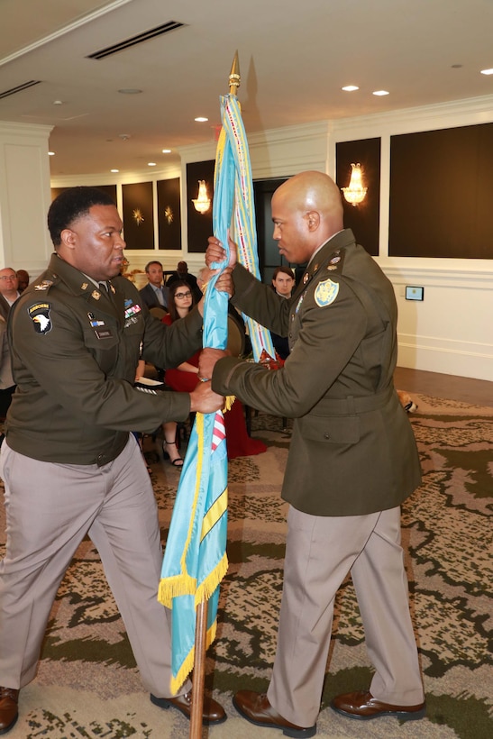 One man passes a flag to another