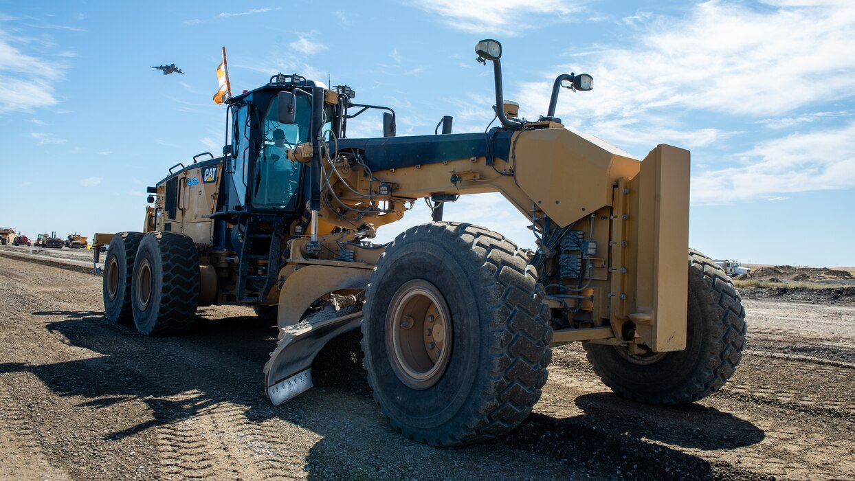 Construction crew working on flight line with a grader