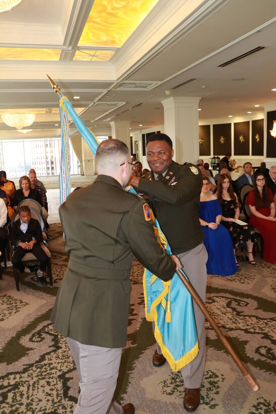 One man passing a flag to another